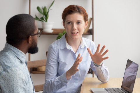 Caucasian female sharing ideas or startup business plan with black male coworker.
